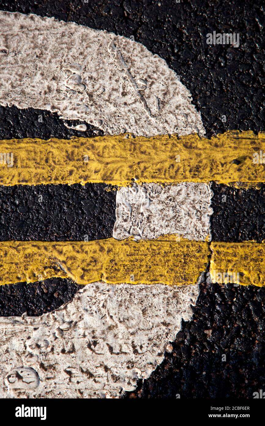 Un primo piano di segnaletica stradale con doppia linea gialla a lato del marciapiede Foto Stock