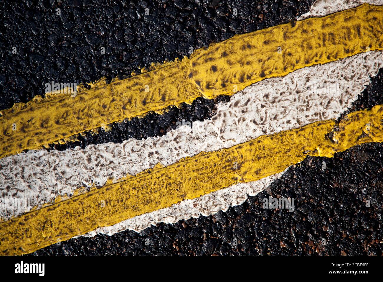 Un primo piano di segnaletica stradale con doppia linea gialla a lato del marciapiede Foto Stock