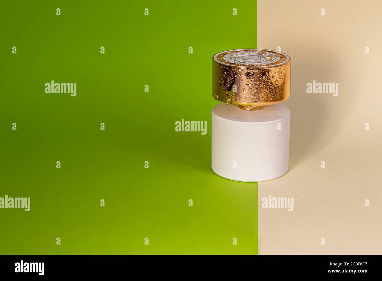 Bottiglia bianca con profumo da donna. Su fogli di carta verde e giallo. Spazio di copia Foto Stock
