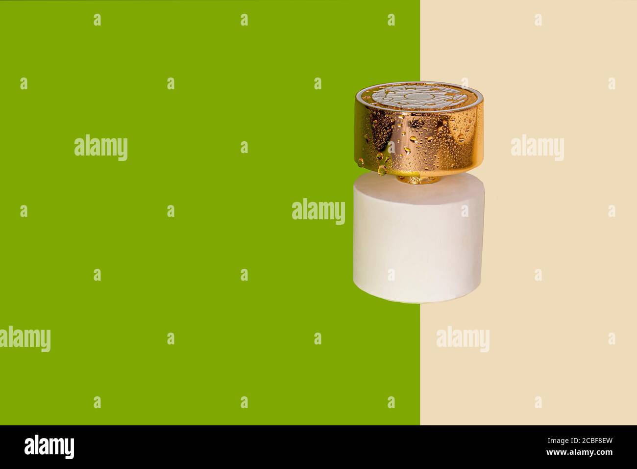 Bottiglia bianca con profumo da donna. Su fogli di carta verde e giallo. Spazio di copia Foto Stock