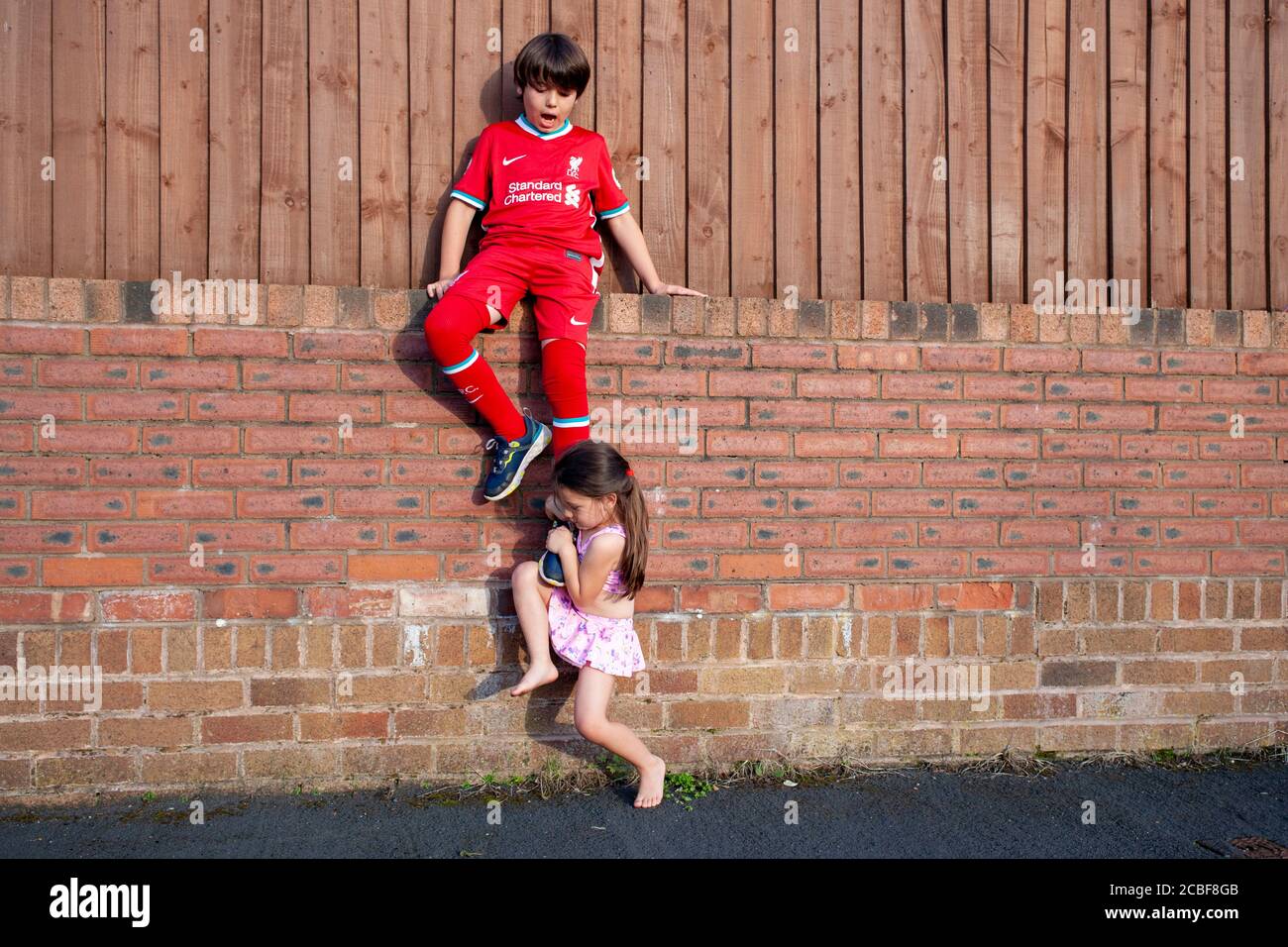 Rivalità tra un ragazzo caucasico di 9 anni e la sua sorella di 4 anni, Lancashire, Inghilterra, Regno Unito Foto Stock