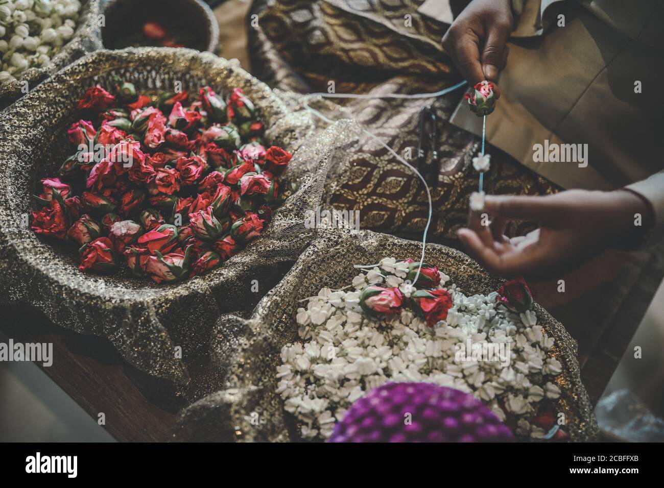 Persona che fa la collana dai fiori secchi Foto Stock
