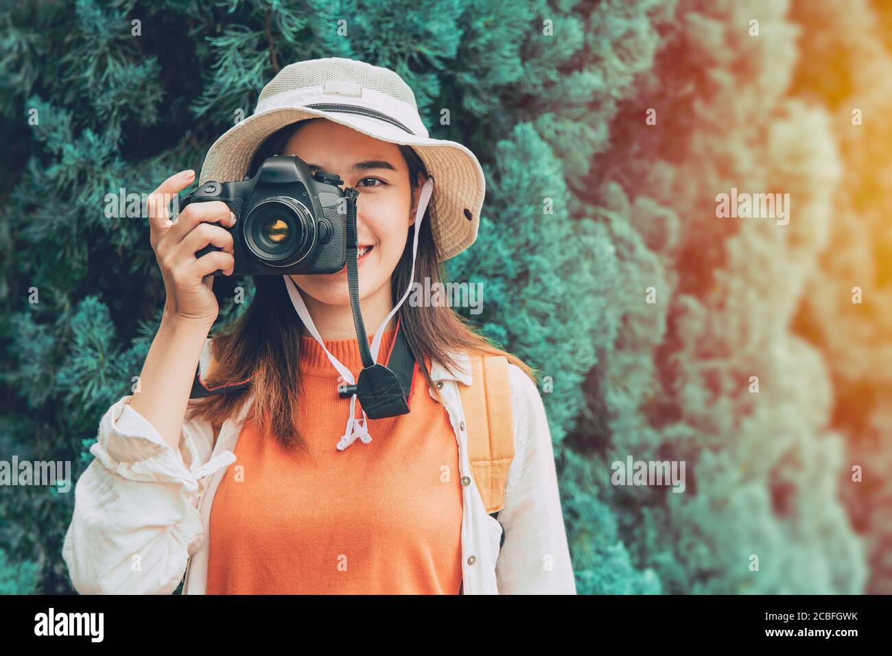 Pritty giovane fotografo asiatico ragazza teen viaggio con fotocamera viaggio scatta una foto di uno stile di vita turistico che sorride con il cappello Foto Stock