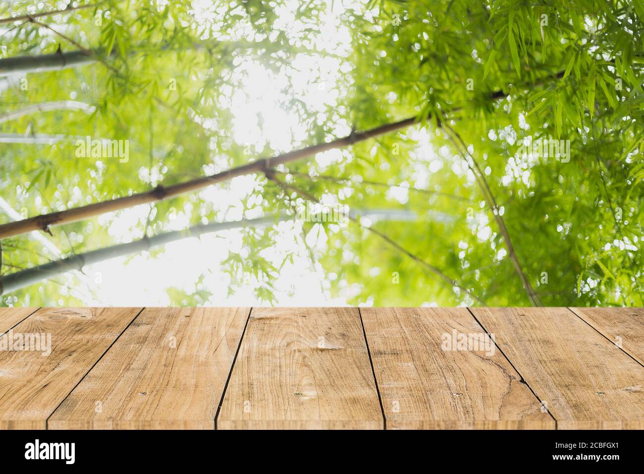 blur albero verde foresta di bambù con tavolo in legno per prodotti montaggio sfondo pubblicitario Foto Stock