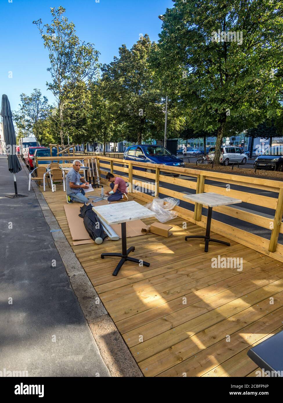 Lavoratori che costruiscono la piattaforma a bordo strada di fronte al ristorante nel quartiere Madeleine di Nantes, Loire-Atlantique, Francia. Foto Stock