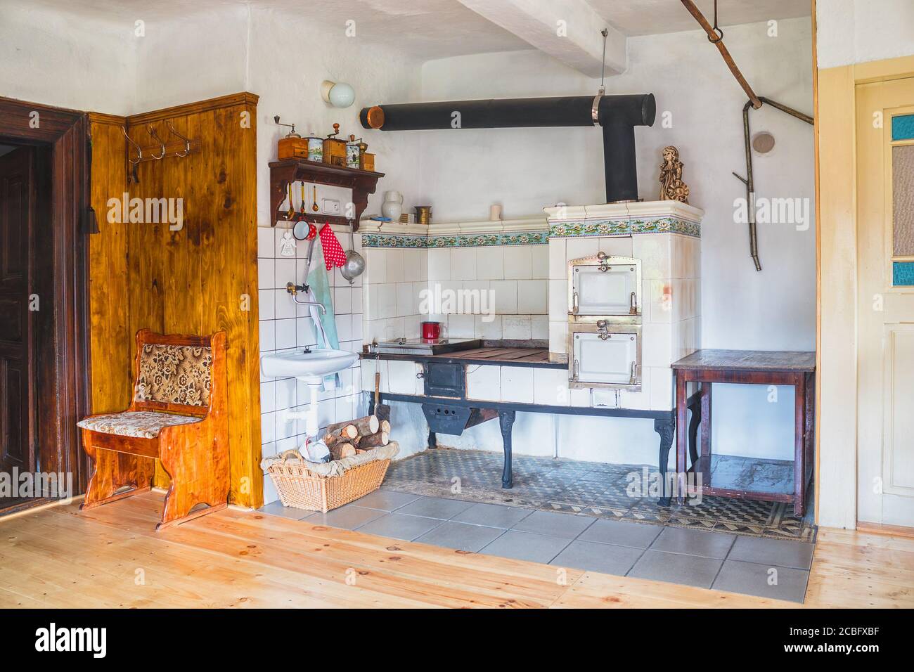 tradizionale cucina antica in un cottage in legno con piastrelle piano cottura Foto Stock