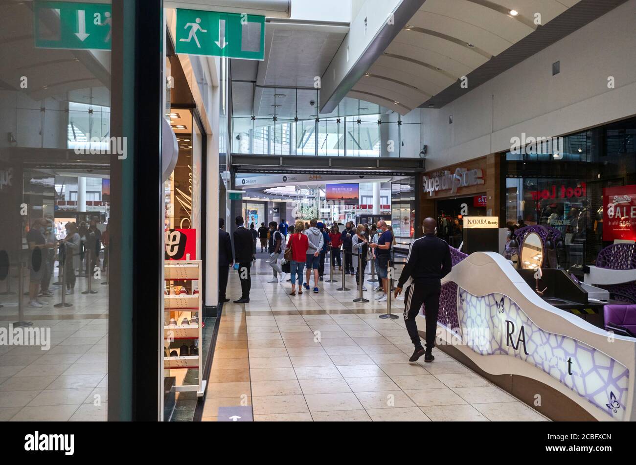 Gli amanti dello shopping nel centro commerciale Intu a Milton Keynes Queue Al di fuori dell'AppleStore indossare maschere facciali durante le norme Covid-19 Foto Stock