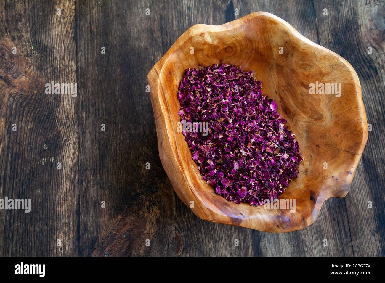 Petali di rosa secchi in una ciotola di legno Foto Stock