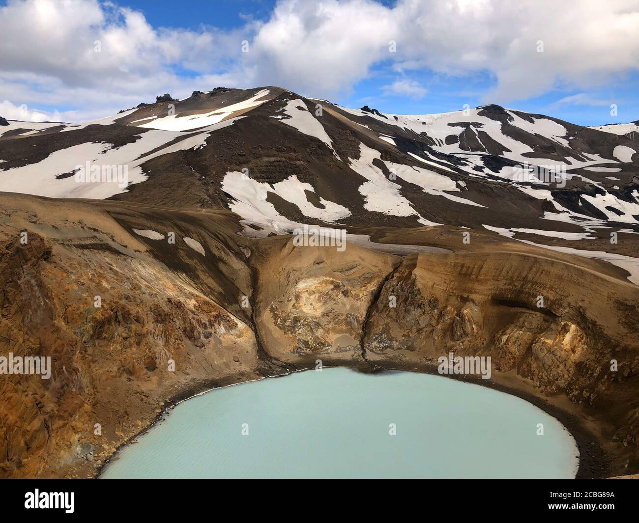 Vista sul cratere di viti della Caldera di Krafla con il lago geotermico E montagne in lontananza Foto Stock