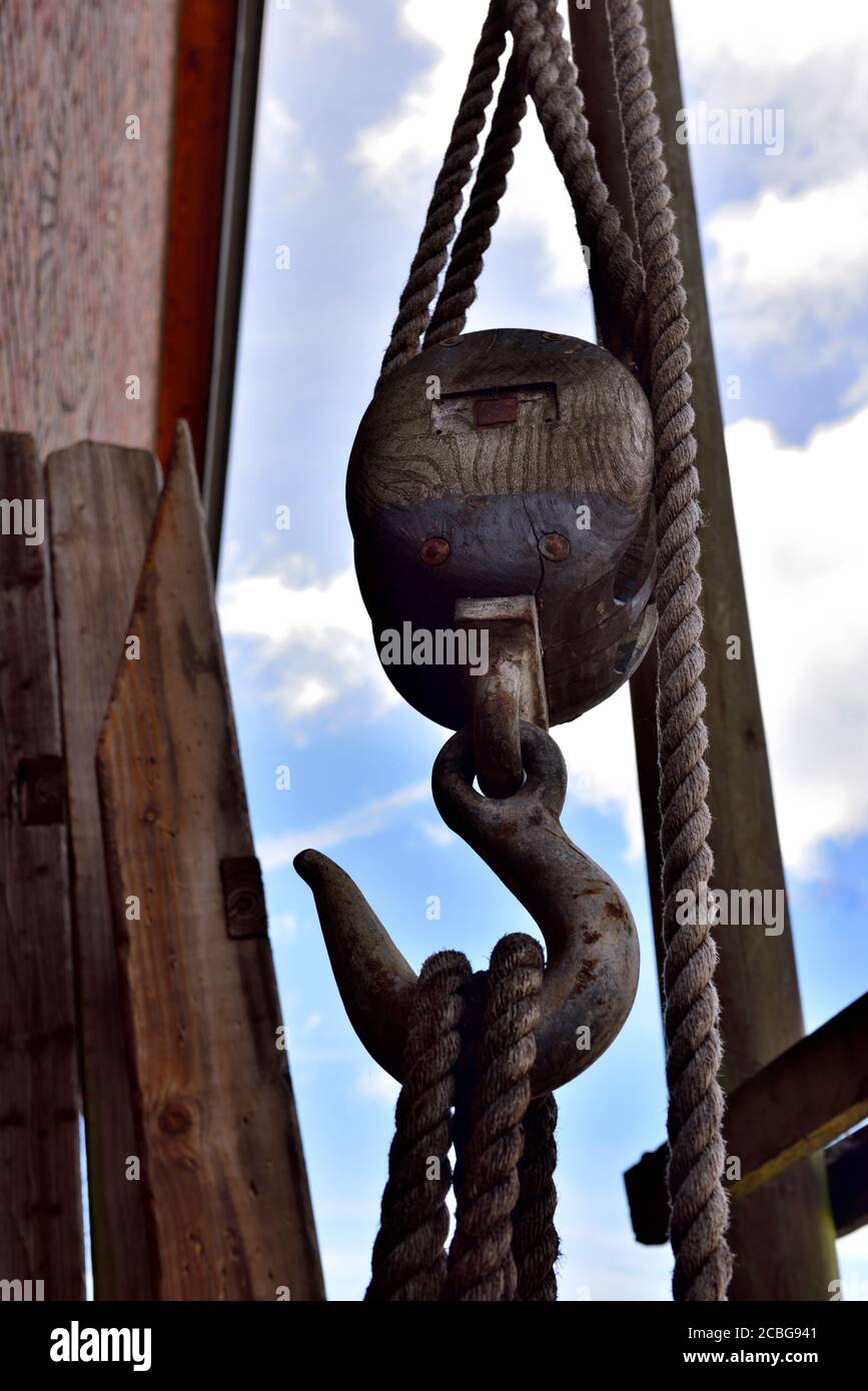 Vecchio blocco di legno e puleggia di attacco con gancio per il sollevamento Foto Stock