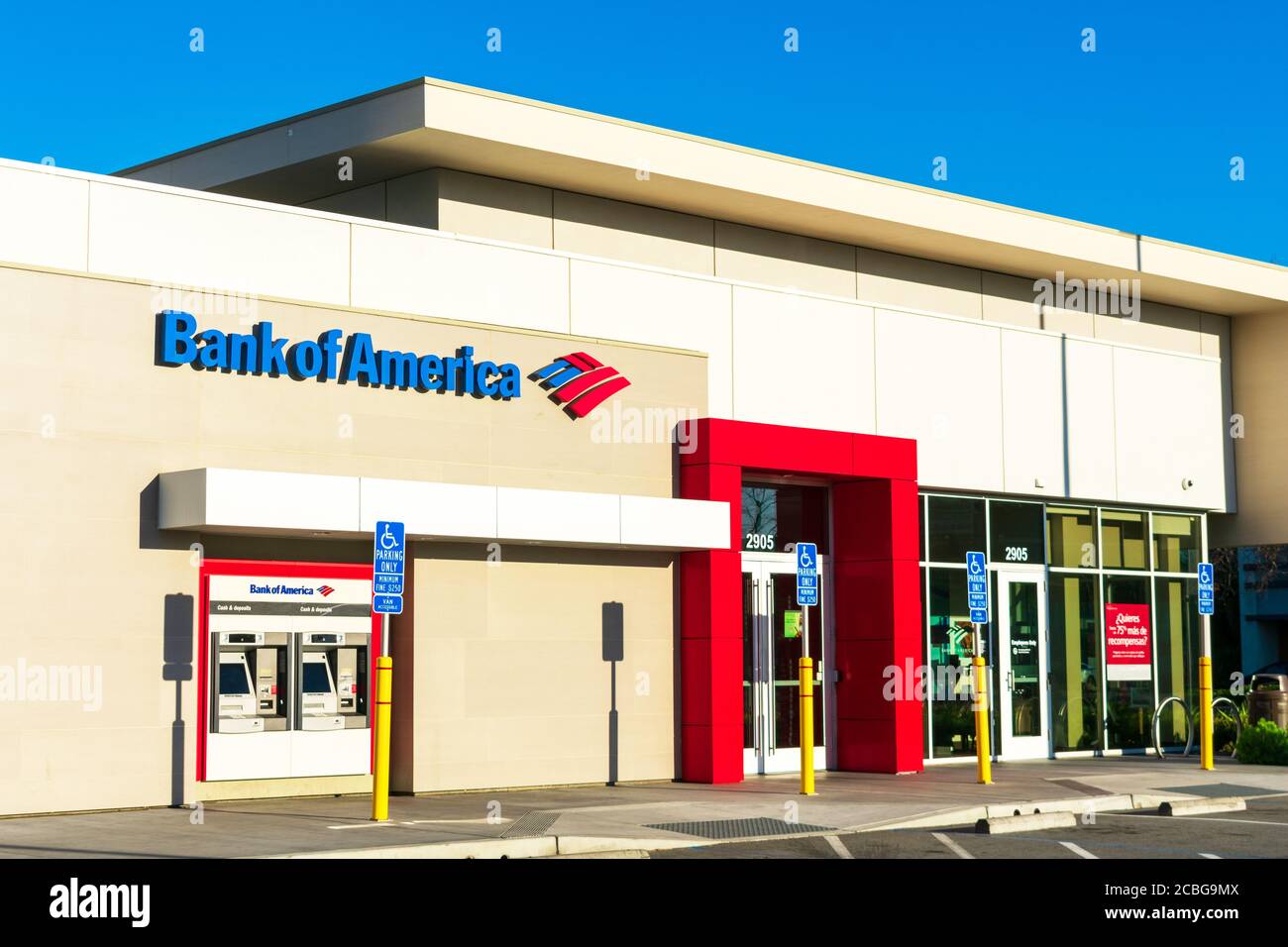Facciata ed esterno della filiale della Bank of America con due sportelli Bancomat all'aperto. Posti auto accessibili vicino all'ingresso chiuso della banca - Foto Stock