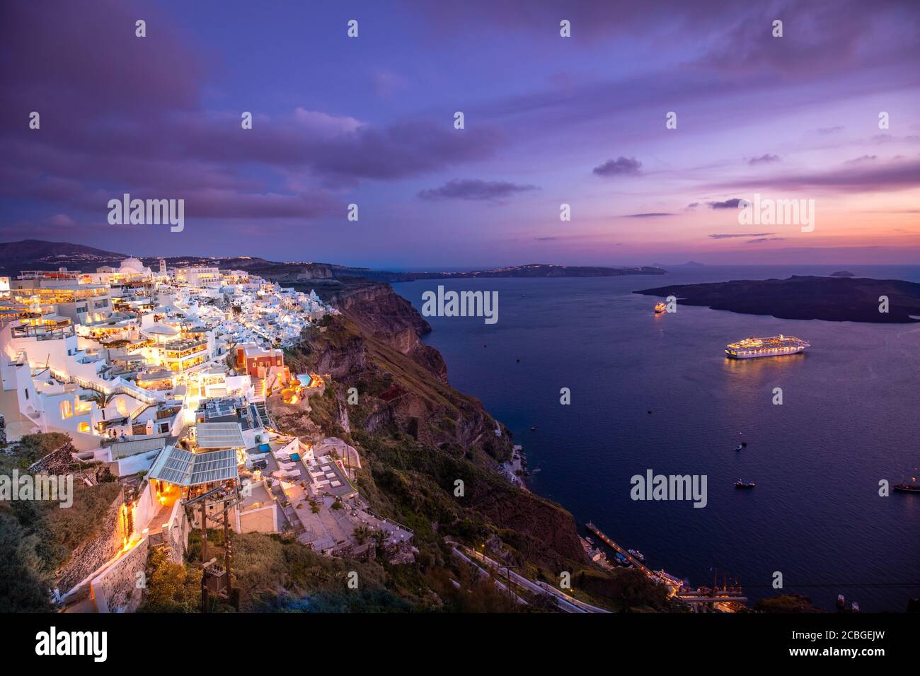 Romantica isola di Santorini al tramonto, Grecia, Europa. Romantica destinazione coppia navi da crociera incredibile tramonto cielo luci della città. Paesaggio incredibile Foto Stock