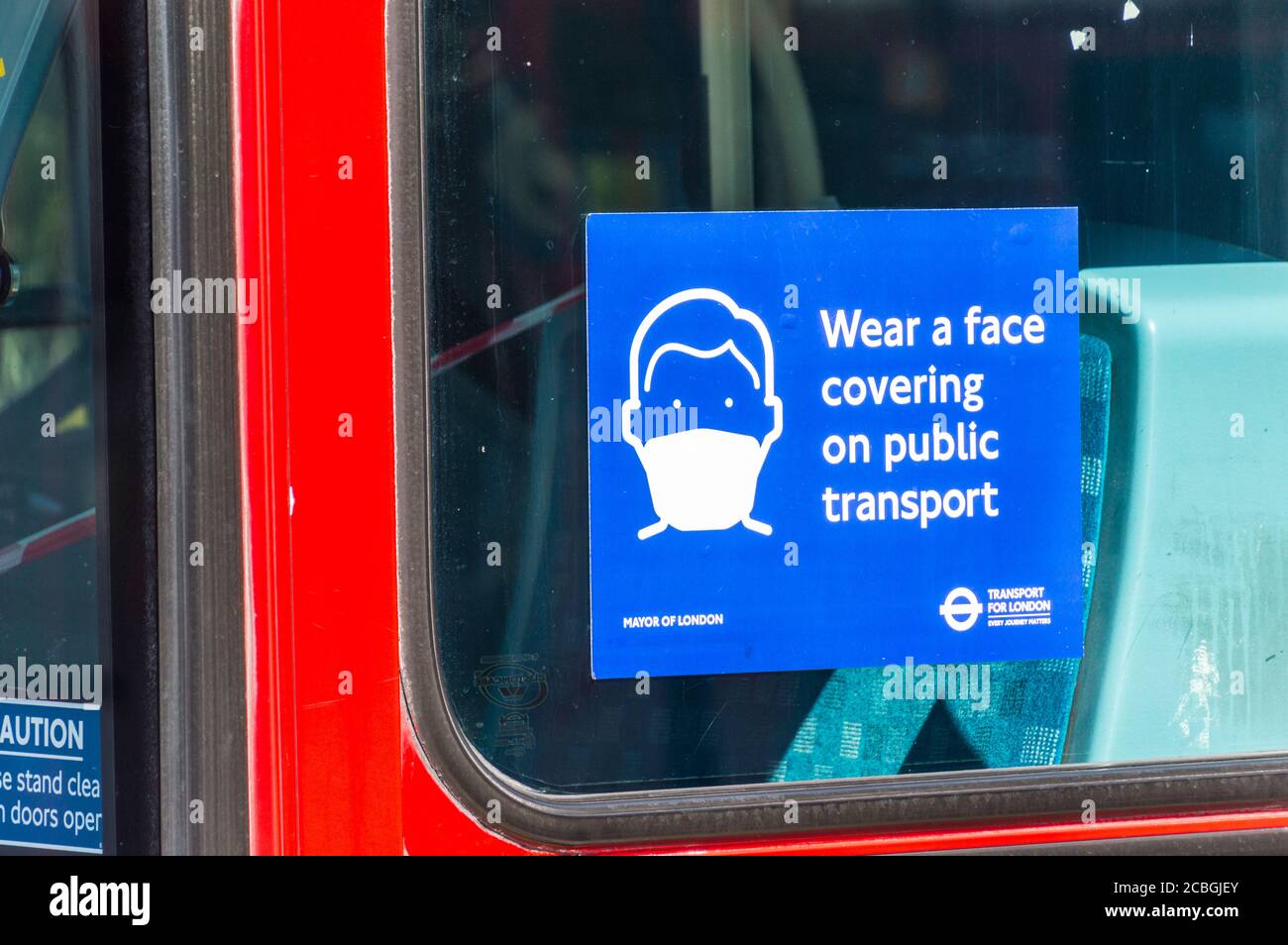 Indossare una copertura facciale sul poster dei trasporti pubblici di Londra autobus durante la covid 19 o pandemia coronavirus Foto Stock