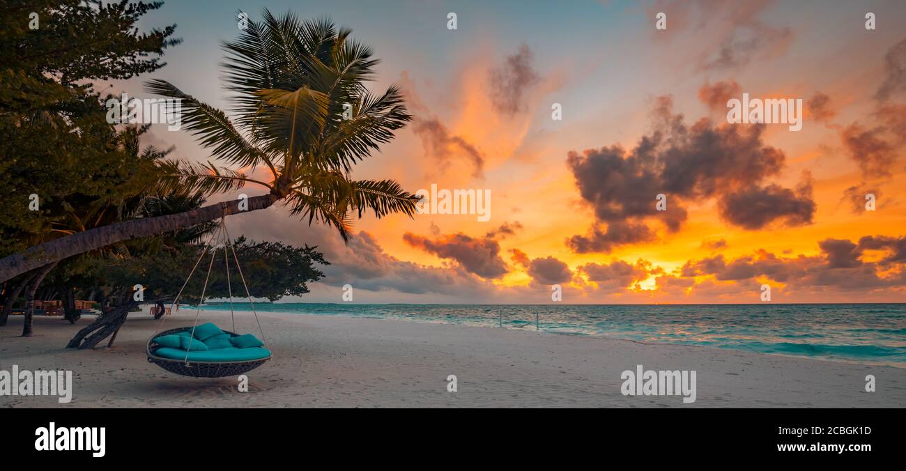 Sfondo tropicale della spiaggia del tramonto come panorama estivo con amaca swing spiaggia e sabbia bianca e banner mare calmo. Perfetta spiaggia Foto Stock