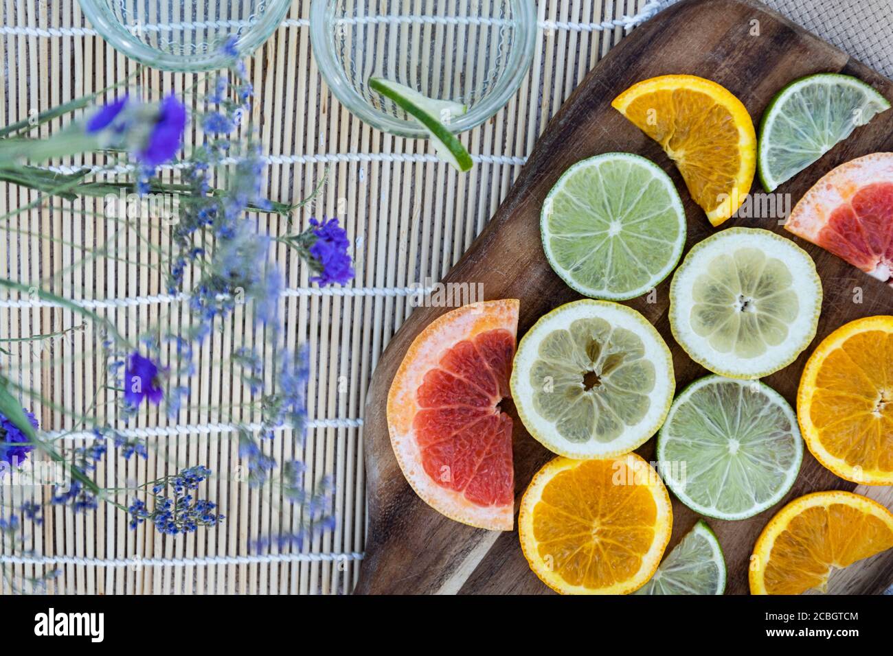 Fette di lavanda e agrumi in un lussuoso picnic estivo piatto allestito in campagna Foto Stock