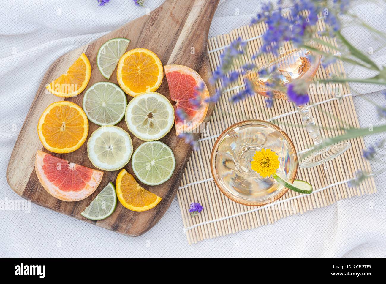 Lavanda, fette di agrumi e champagne in un lussuoso picnic estivo allestito in campagna Foto Stock