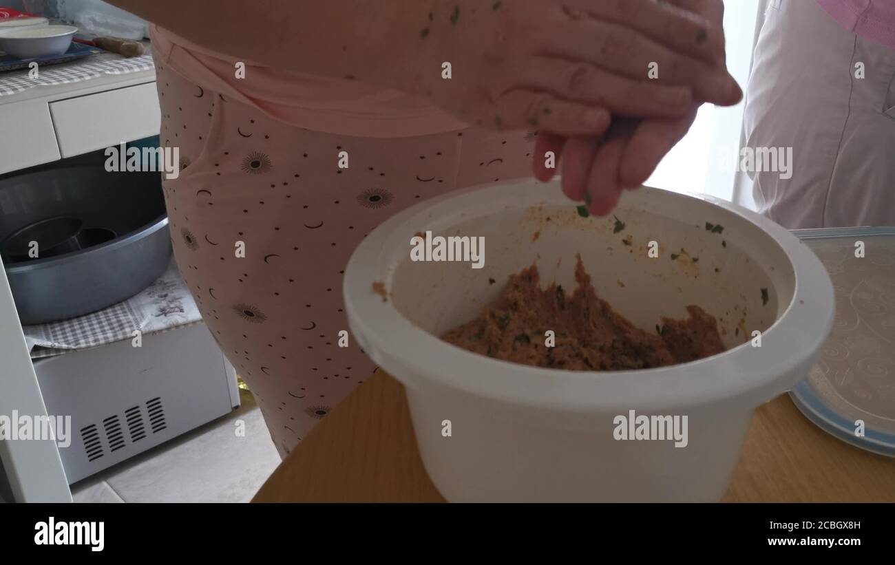 Bistecca sminuzzata, preparazione di polpette, impasto di carne a mano nel recipiente. Vista ravvicinata Foto Stock