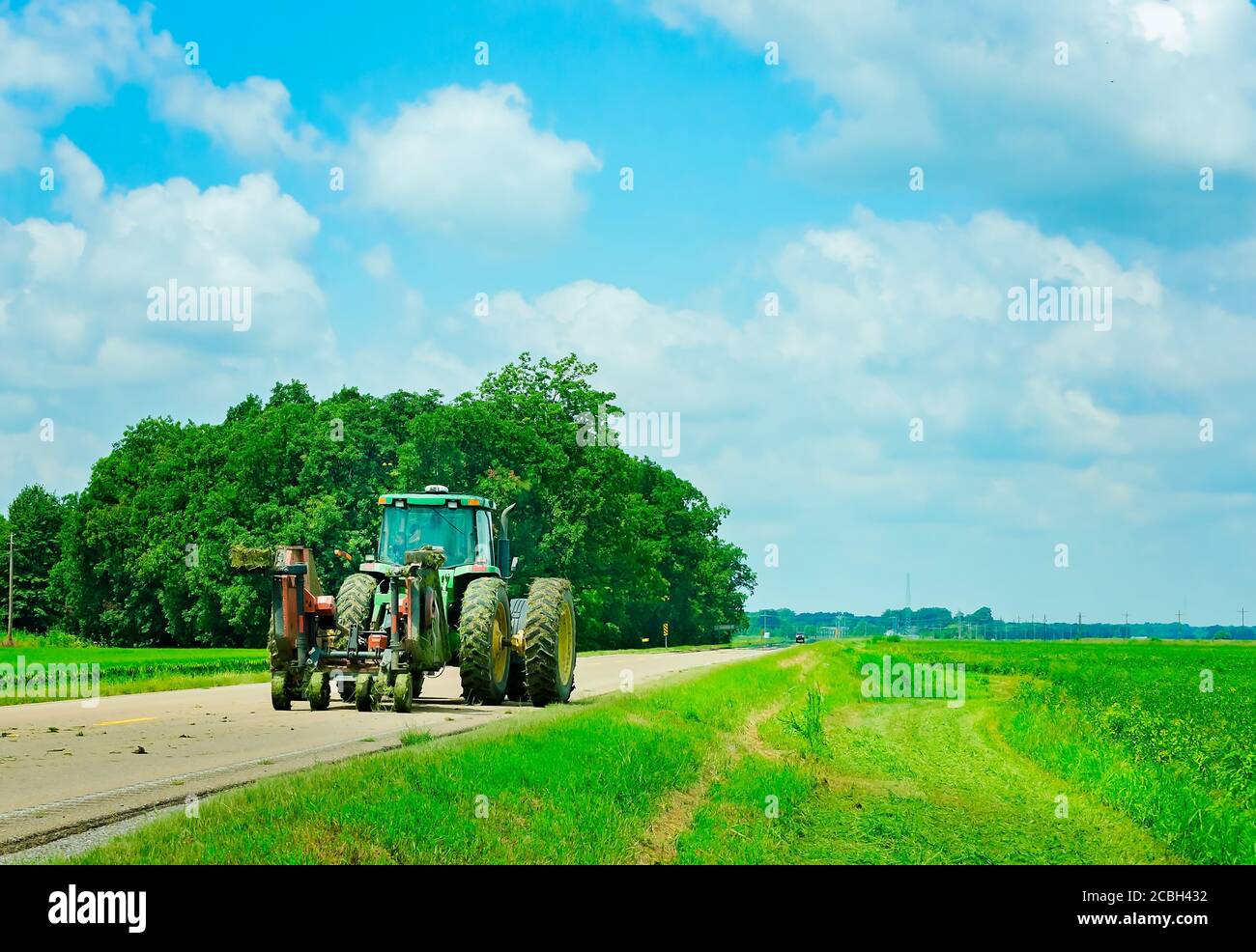 Un agricoltore guida il suo trattore lungo la strada, l'8 agosto 2016, a Rosedale, Mississippi. Foto Stock