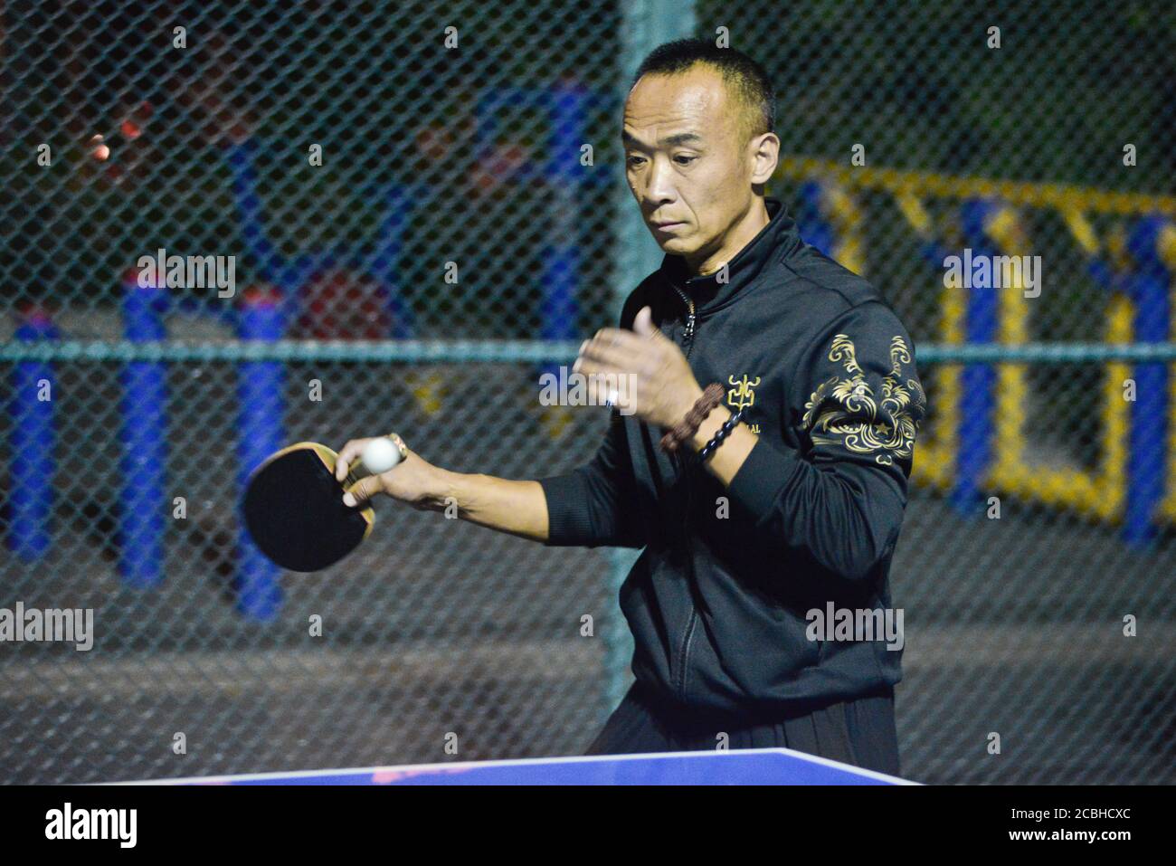Uomo cinese che gioca a ping pong in un parco pubblico, Pechino, Cina Foto Stock