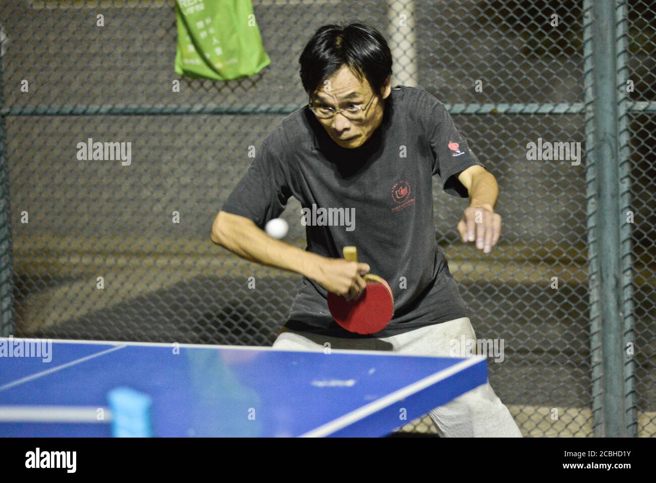 Uomo cinese che gioca a ping pong in un parco pubblico, Pechino, Cina Foto Stock