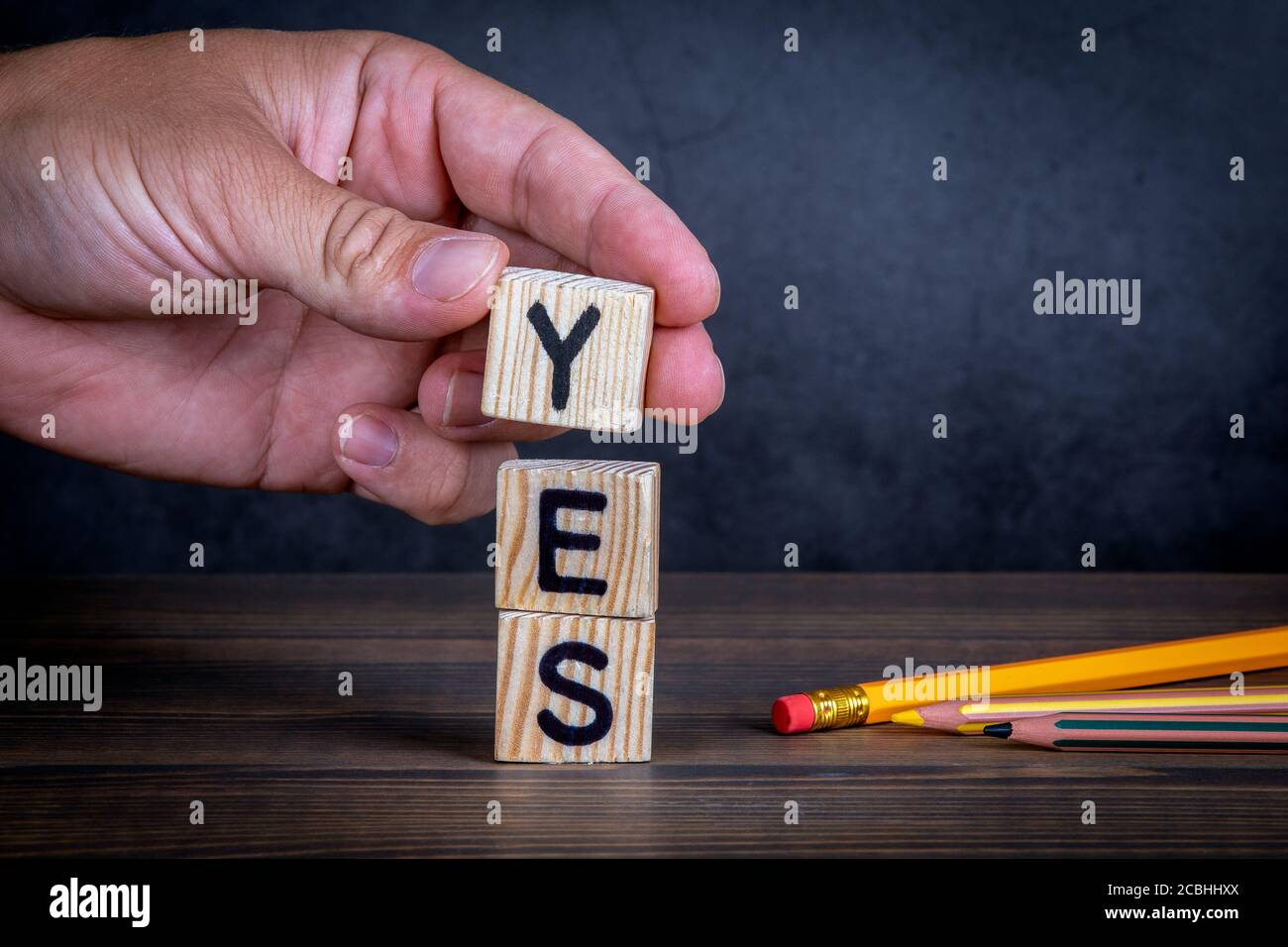 SÌ. Concetto di approvazione, supporto e consenso. Lettere alfabetiche e matite in legno sul tavolo Foto Stock