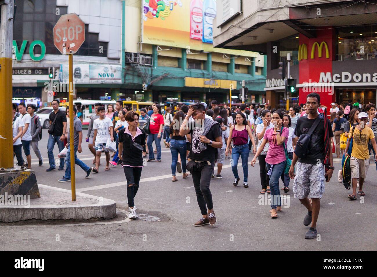 Cebu / Filippine - 10 luglio 2019: Filippino persone che attraversano la strada trafficata nella zona commerciale di Cebu Foto Stock