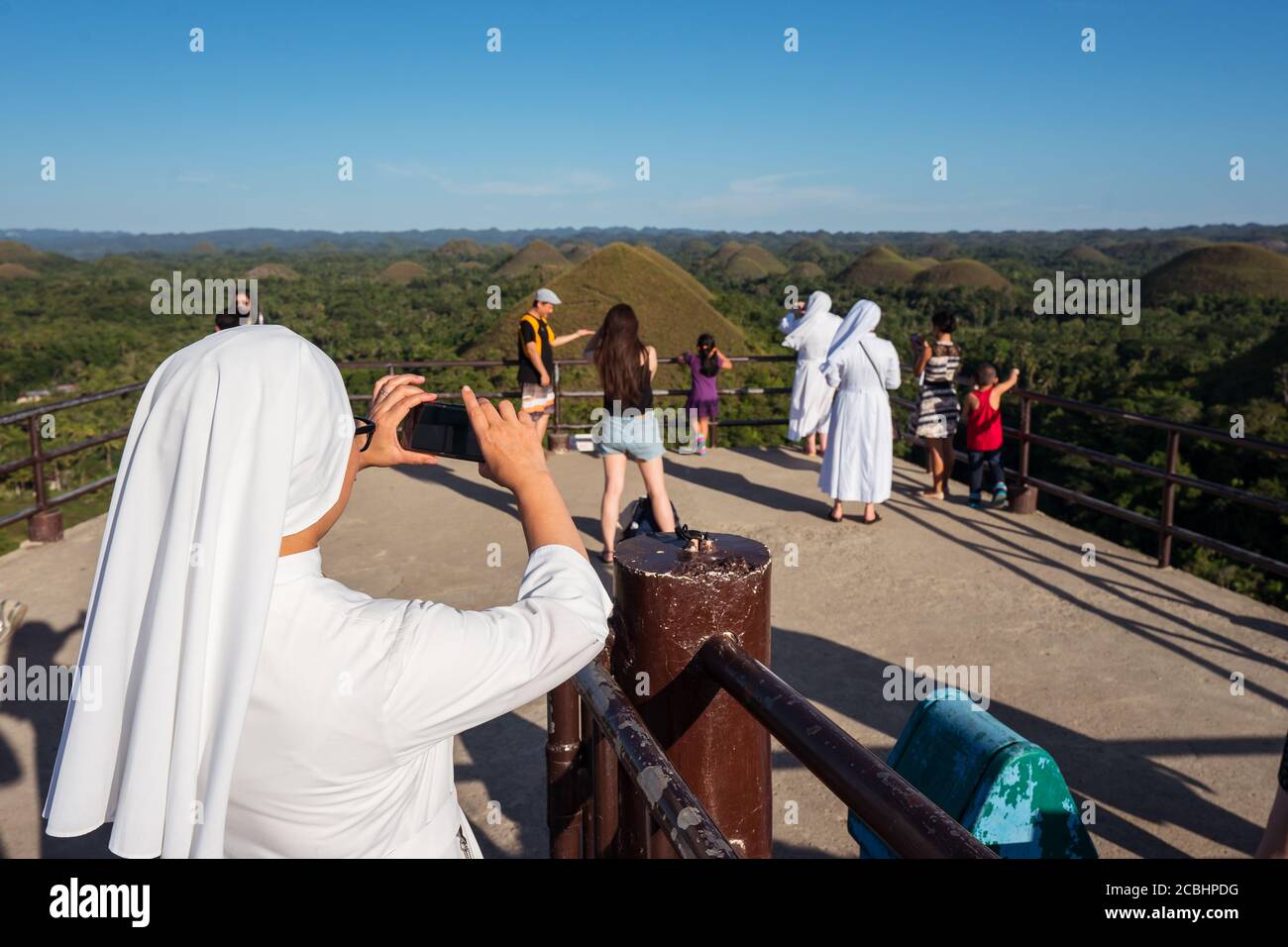 Bohol / Filippine - 18 luglio 2019: Monaca cattolica cristiana scattare foto con smartphone nelle famose colline di cioccolato di Bohol Foto Stock