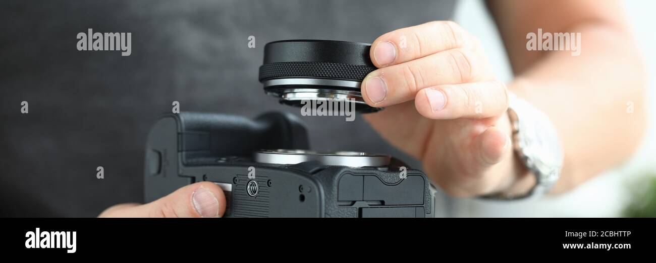 Mani maschili che indossano un moderno adattatore per obiettivo per fotocamera digitale Foto Stock