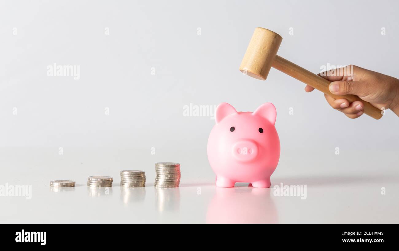 Mano di capretto che tiene moneta messo in banca piggy con pila di soldi crescente crescita che risparmia denaro, concetto di investimento per il piano di libertà finanziaria, business. Foto Stock