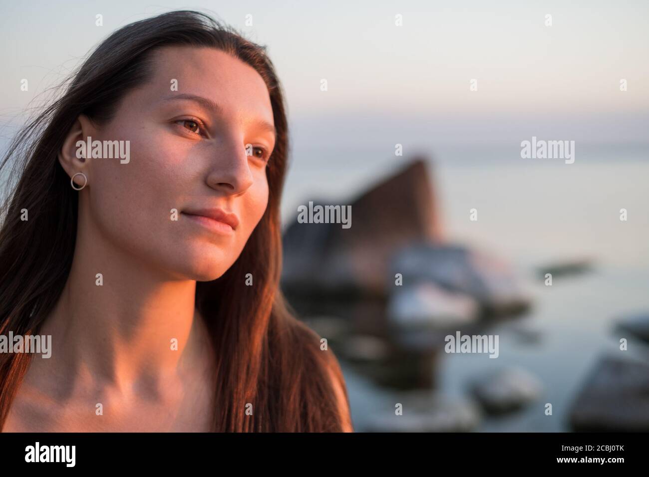 Donna sognante che riposa vicino al mare Foto Stock