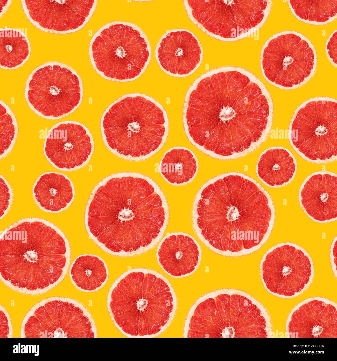 Disegno senza cuciture della sezione trasversale del pompelmo. Vista dall'alto delle metà rosa succose di pompelmo su sfondo giallo. Mockup per stampa su tessuto, carta da imballaggio Foto Stock