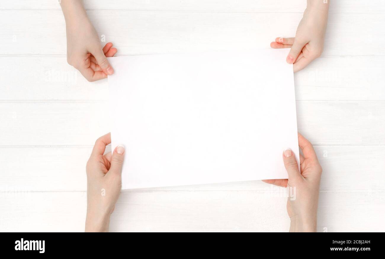 Mani che tengono un foglio di carta A4 vuoto per la progettazione Foto Stock