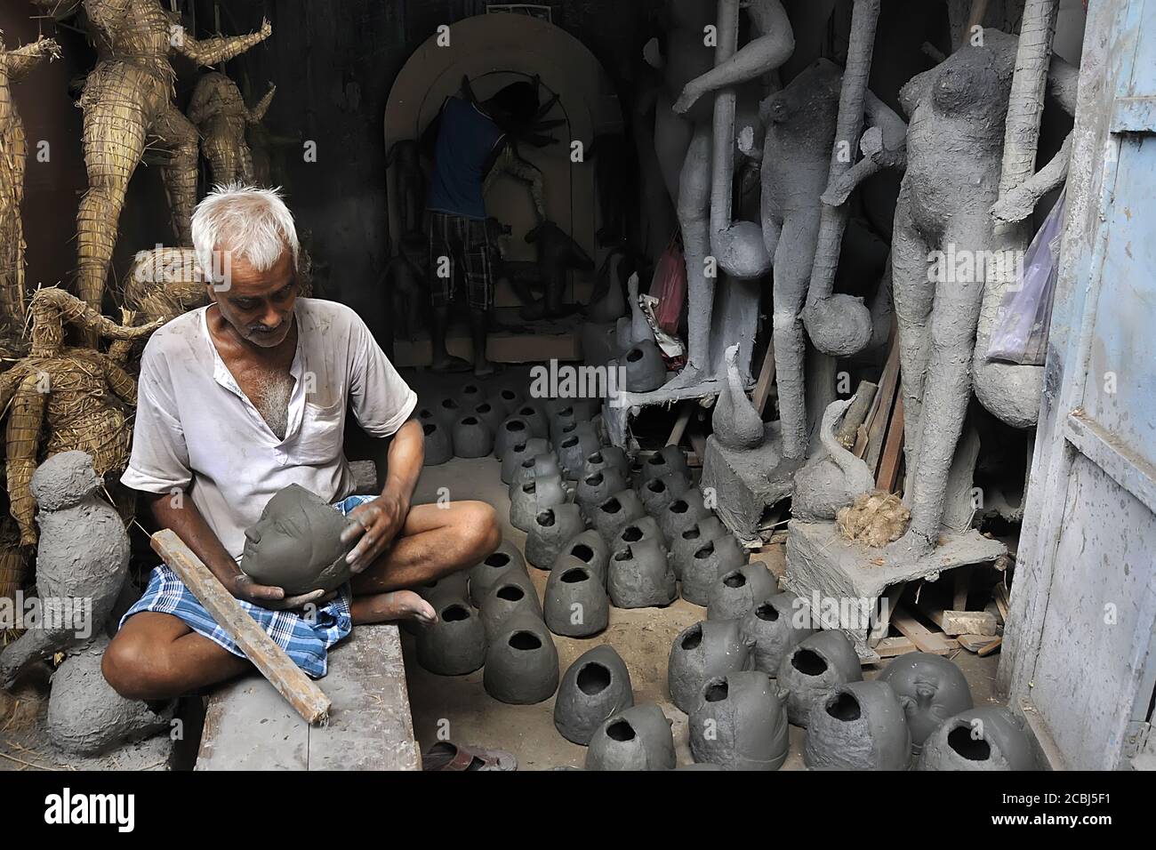 Artigiano argilla rendendo gli idoli della dea Durga prima di Durga Puja Festival Kumartuli Kolkata West Bengal India Foto Stock