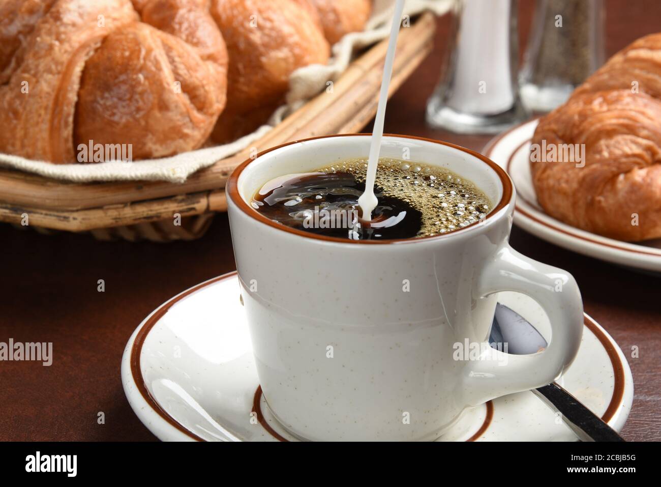 Versare la crema di caffè in una tazza, foto in freeze motion ad alta velocità Foto Stock