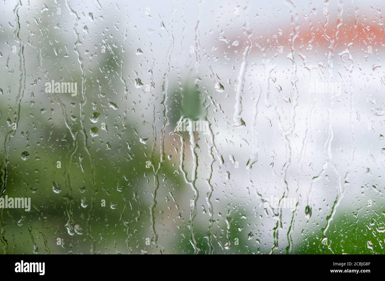 Gocce di pioggia che colpiscono il vetro della finestra Foto Stock