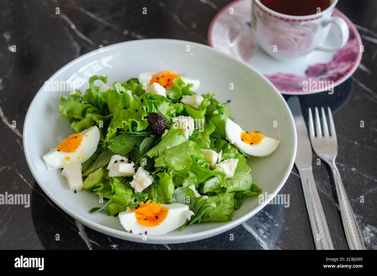 Insalata di verdure fresche con lattuga, aneto, porslane, pepe, formaggio, uova e olive nere Foto Stock