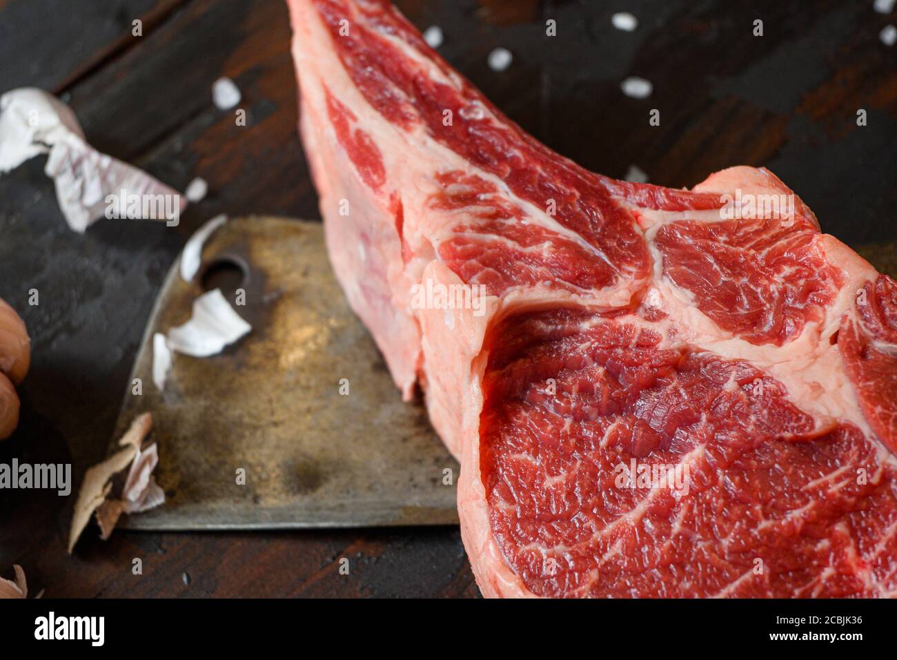 Manzo crudo Dallas bistecca, che si trova sul coltello da taglio. Carne di manzo cruda preparata per cucinare le bistecche. Oltre agli ingredienti per cucinare bistecche, spezie Foto Stock