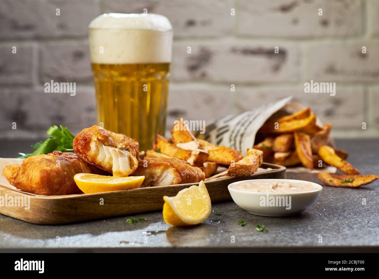 Pesce e patatine con birra su tavola di pietra Foto Stock