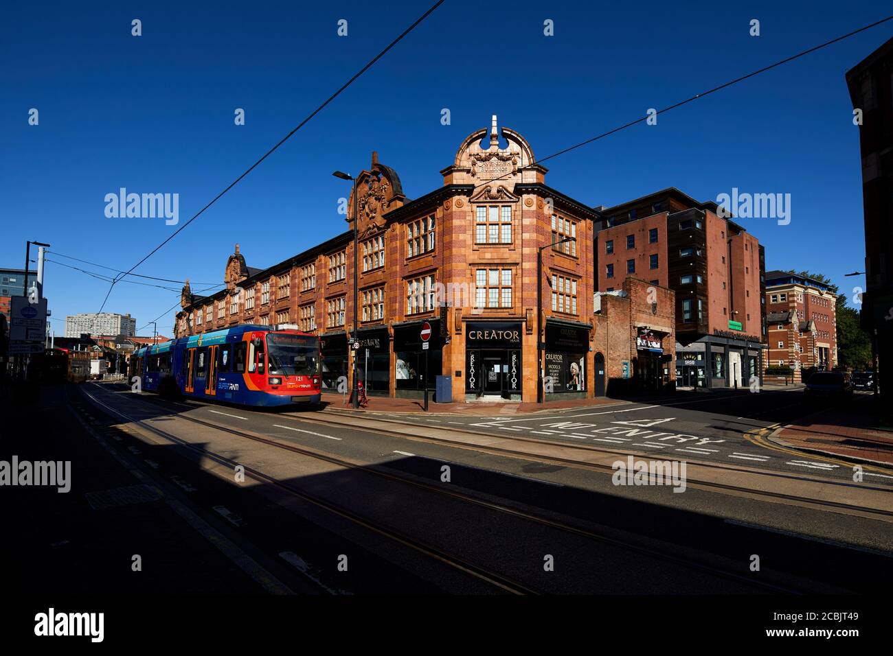 Città di Sheffield, negozi vittoriani West Street con un supertram Stagecoach che passa Foto Stock