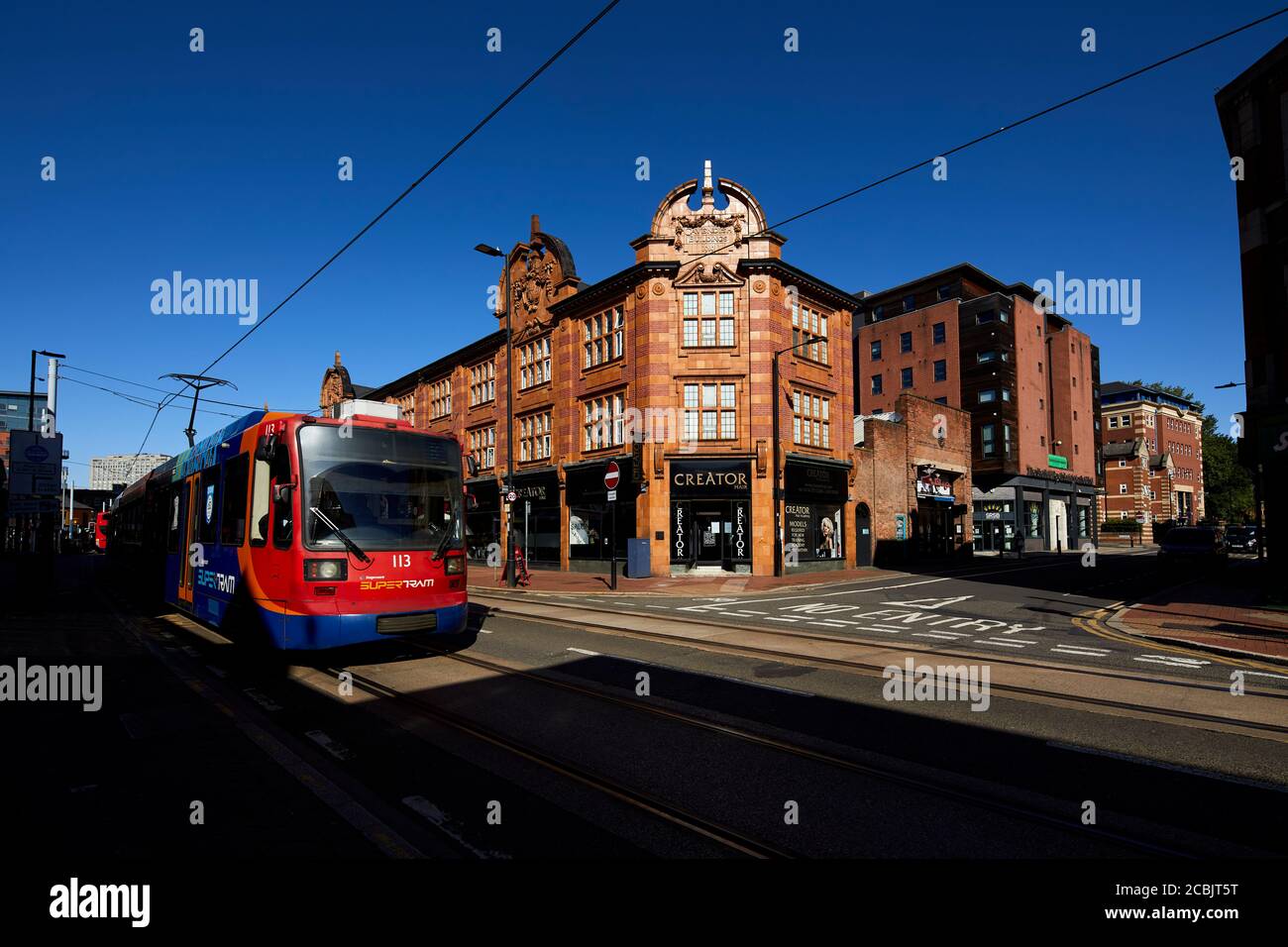 Città di Sheffield, negozi vittoriani West Street con un supertram Stagecoach che passa Foto Stock