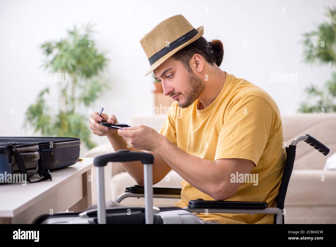 Giovane in sedia a rotelle che si prepara alla partenza Foto Stock