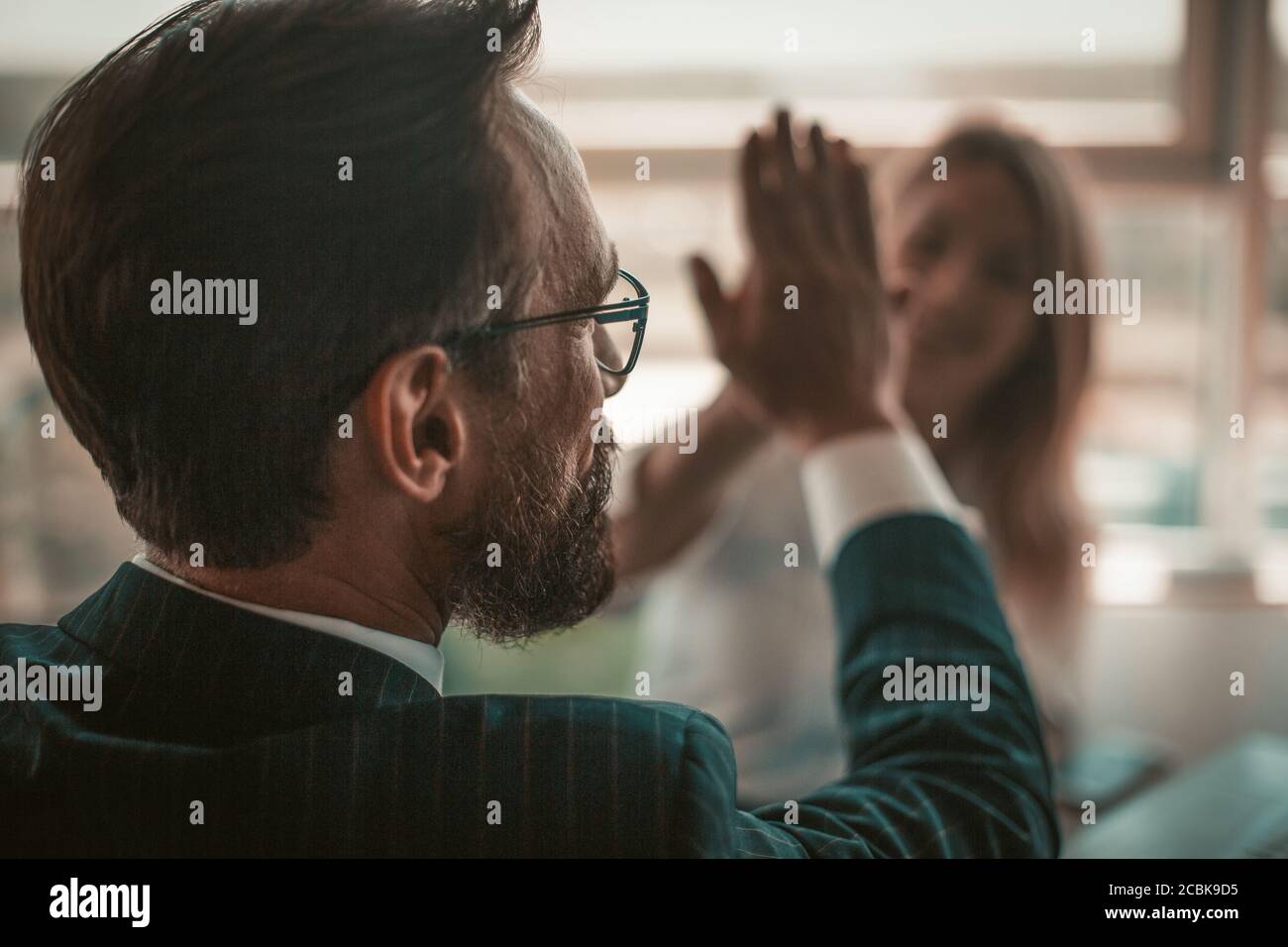 I project manager positivi celebrano l'accordo di successo. Entusiasta gente di affari che si dà cinque in segno di buon lavoro e di solidarietà delle mani Foto Stock