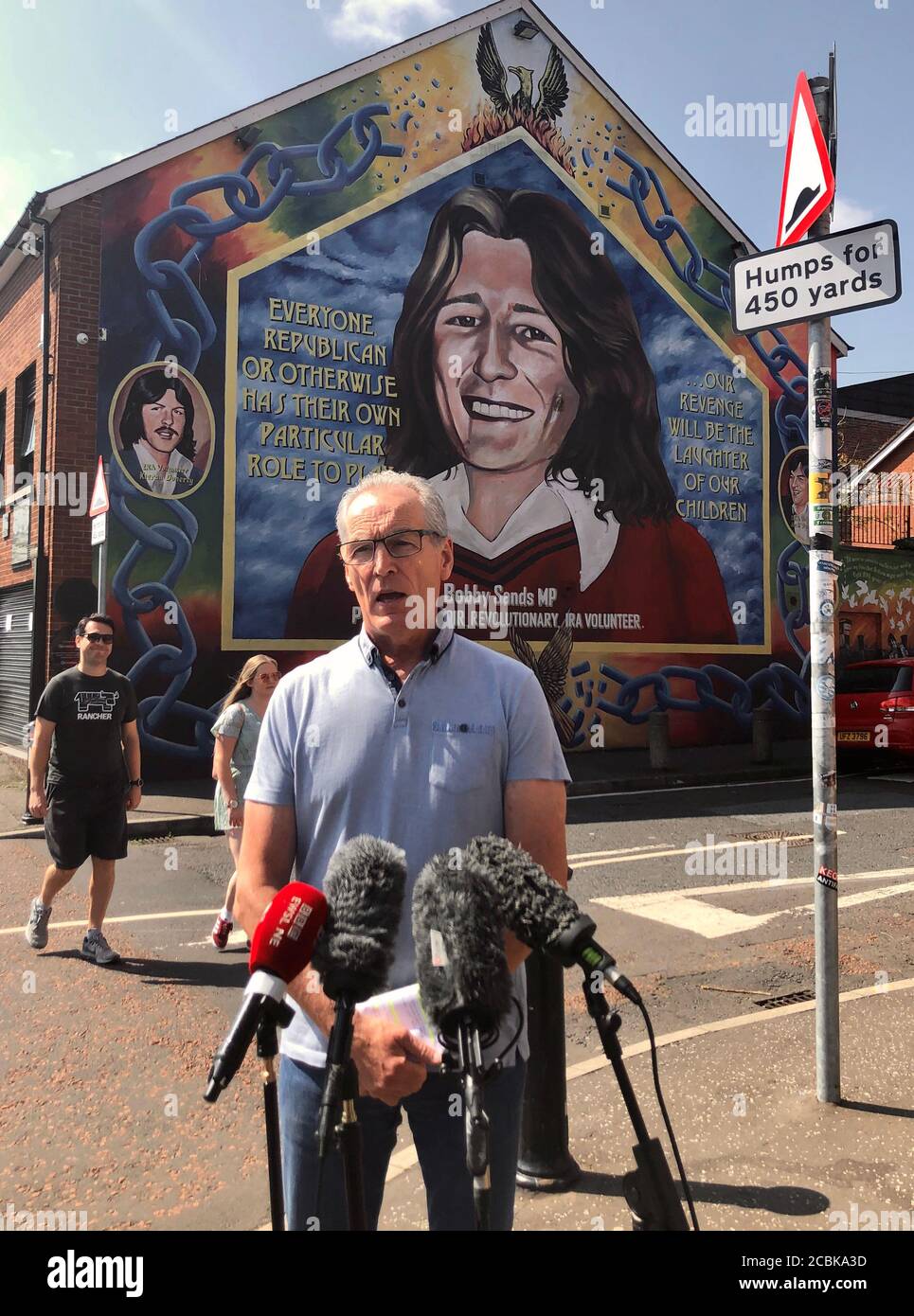 Sinn Fein MLA Gerry Kelly presso l'ufficio Falls Road del partito a Belfast, rispondendo alle indicazioni del governo sull'amministrazione dei pagamenti di risarcimento delle vittime. Foto Stock