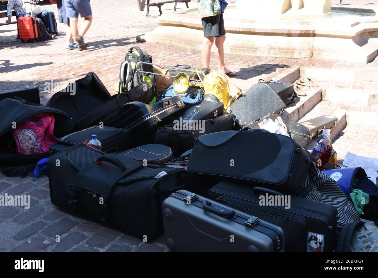 Mucchio di casse o scatole per strumenti a vento e tamburi di musicisti di strada nella città di Colmar, Francia durante il fine settimana di giorno estivo per rallegrare i turisti. Foto Stock