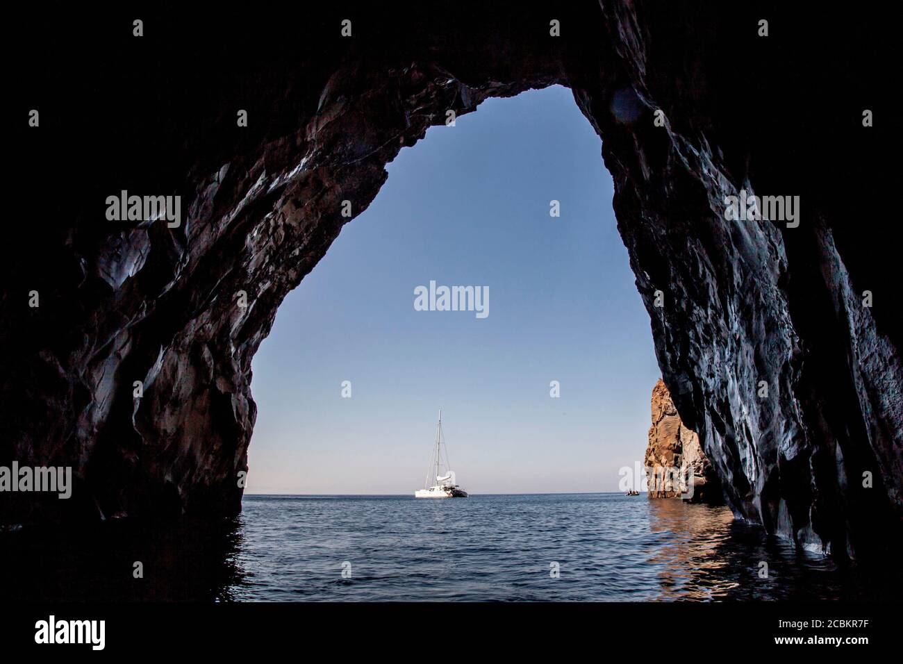 Barca a vela vista dalla grotta in oceano Foto Stock