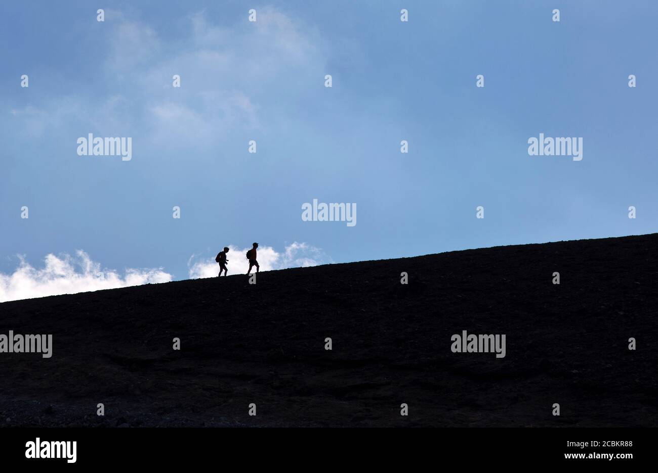 Silhouette di escursionisti su pendii polverosi Foto Stock