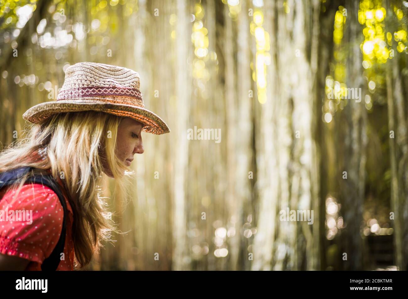 Profilo della donna mid adult che indossa cappello nella foresta, Ubud, Bali, Indonesia Foto Stock