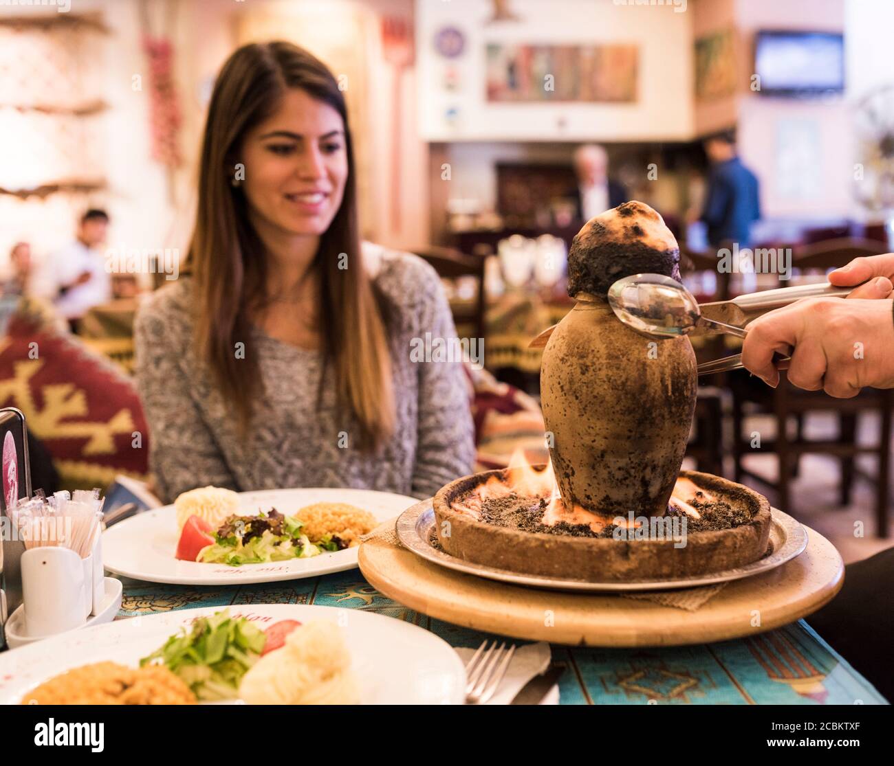 Giovane donna che viene servita cibo in ristorante, Istanbul, Turchia Foto Stock