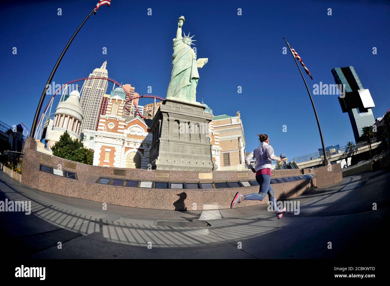 Runner femminile di media età che corre di fronte alla statua della libertà sulla Las Vegas Strip, Las Vegas, Nevada, USA Foto Stock
