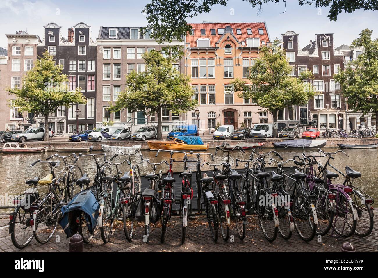 Fila di biciclette parcheggiate vicino al canale, Amsterdam, Paesi Bassi Foto Stock